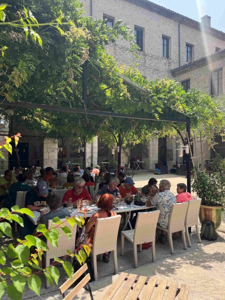 groupe déjeunant sous la glycine du Cloître des Dominicains